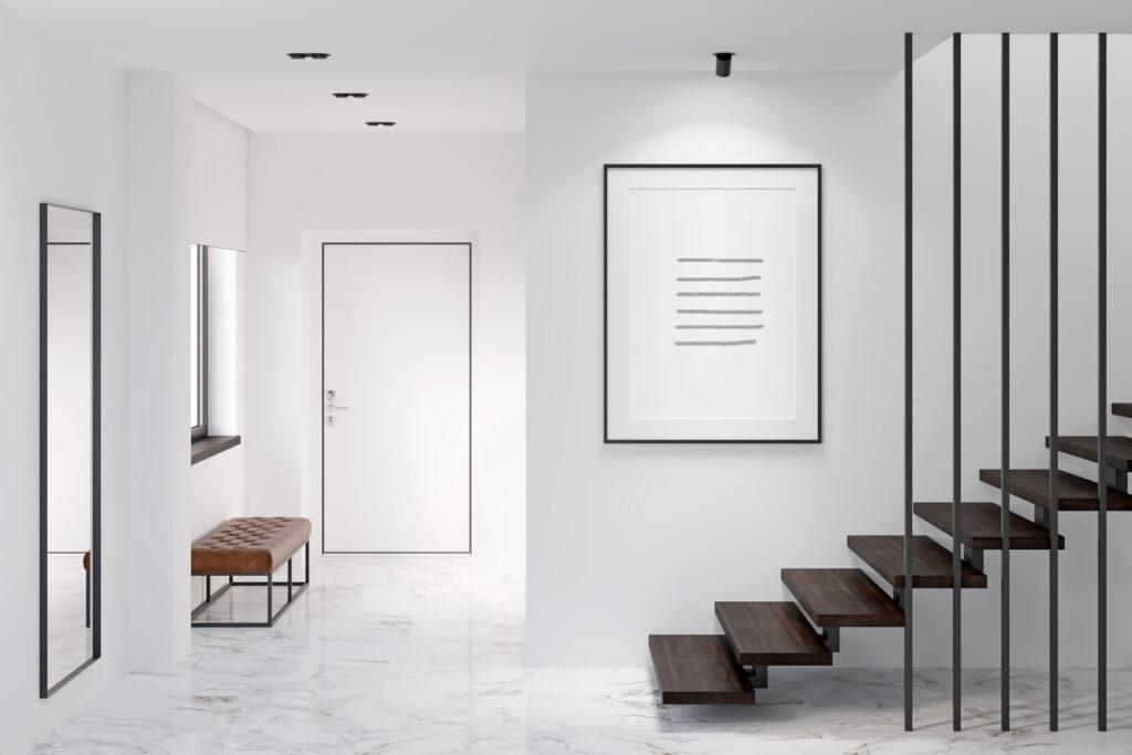 Weiße moderne, minimalistische Lobby, mit weißer Tür, brauner Wendeltreppe und Spiegel an der Wand